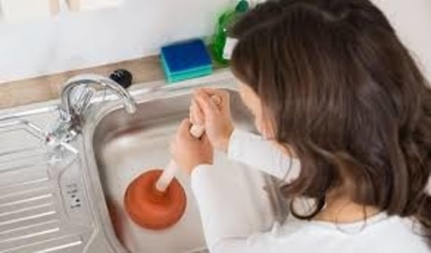 woman plunging clogged sink